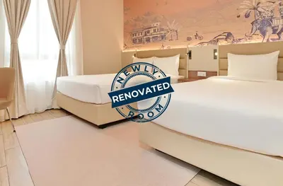 a hotel room with two beds and a sign that reads renovated at Cititel Express Ipoh in Ipoh