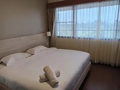 a bedroom with a large bed with a large window at Cozy Nest 1 Bedroom Apartment at Equatorial Hill Resort in Brinchang
