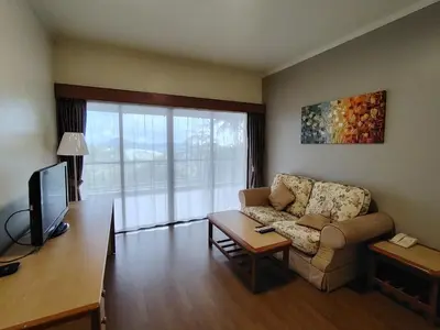 a living room with a couch and a tv at Cozy Nest 1 Bedroom Apartment at Equatorial Hill Resort in Brinchang
