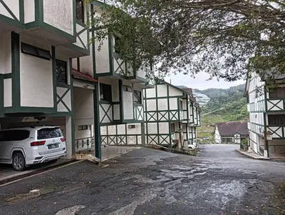 a white van parked in front of a building at Cozy Nest 1 Bedroom Apartment at Equatorial Hill Resort in Brinchang
