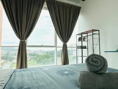 a bedroom with a bed with a large window at Fabulous Airport 2BR Suite# Straits Intl# Msg Chair in Bayan Lepas