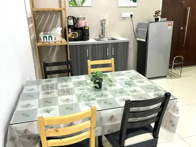a dining room table with two chairs and a kitchen at Fabulous Airport 2BR Suite# Straits Intl# Msg Chair in Bayan Lepas