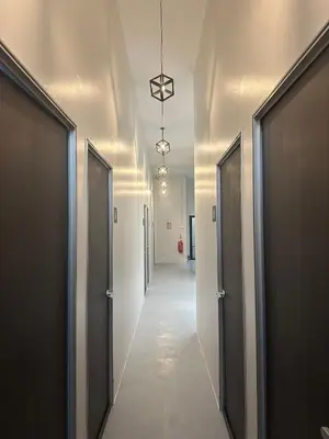a hallway with a row of doors and a hallwayngth at Be Right Back Loft - Alma in Kampong Ayer Merah