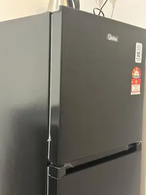 a silver refrigerator with magnets on the side of it at Be Right Back Loft - Alma in Kampong Ayer Merah