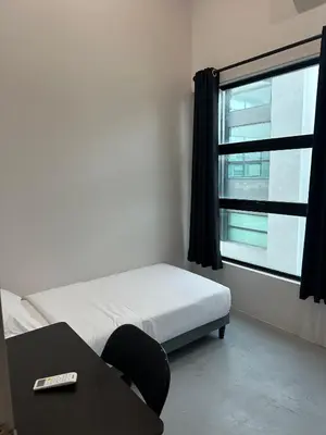 a bedroom with a bed and a desk and a window at Be Right Back Loft - Alma in Kampong Ayer Merah