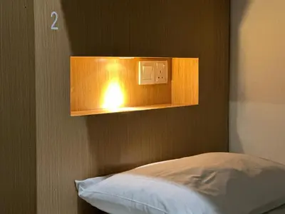 a light on a wall next to a bed at The Frame Guesthouse in George Town