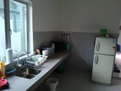 a kitchen with a sink and a white refrigerator at The Welcome Mat Homestay in Seri Iskandar