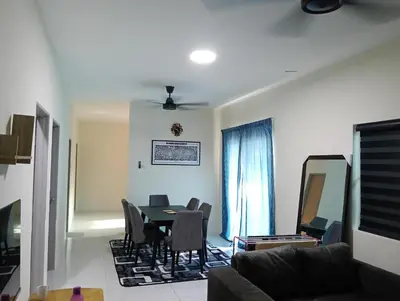 a living room with a table and chairs at The Welcome Mat Homestay in Seri Iskandar