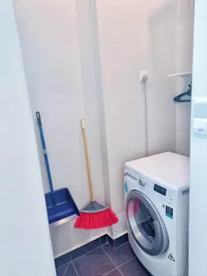 a laundry room with a washing machine and mop at 29th 2BR1B Straits Garden Suites Georgetown Penang in George Town