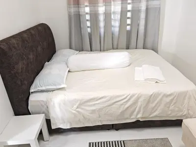 a bed with white sheets and pillows in a room at Modern Comfort Seri Iskandar in Seri Iskandar