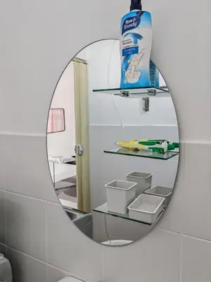 a round mirror in a bathroom with a sink at Modern Comfort Seri Iskandar in Seri Iskandar