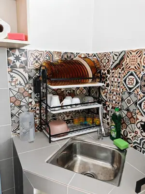 a kitchen with a sink and a tile wall at Modern Comfort Seri Iskandar in Seri Iskandar