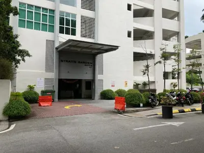 a large white building with motorcycles parked in a parking lot at 28th 2BR1B Straits Garden Suites Georgetown Penang in Jelutong