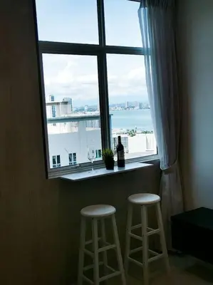a window with a bottle of wine and two stools at 28th 2BR1B Straits Garden Suites Georgetown Penang in Jelutong