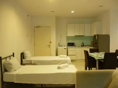 a room with two beds and a table and a kitchen at Studio at Middle floor sea view in George Town