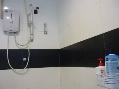 a shower in a bathroom with black and white tiles at Studio at Middle floor sea view in George Town