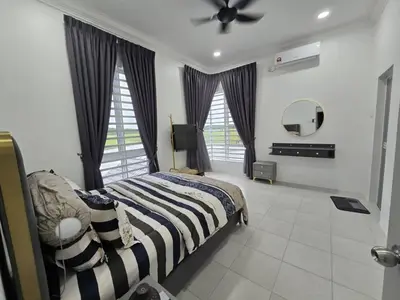 a bedroom with a bed and a ceiling fan at The Bangau Cottage in Sungai Petani