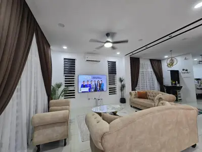 a living room with two couches and a tv at The Bangau Cottage in Sungai Petani