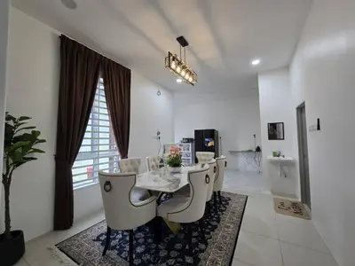a white dining room with a table and chairs at The Bangau Cottage in Sungai Petani