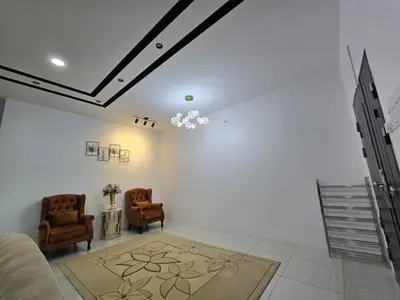 a living room with two chairs and a couch at The Bangau Cottage in Sungai Petani