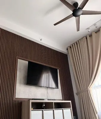 a ceiling fan and a flat screen tv on a wall at NeoSkyhigh Suites in Batu Kawan