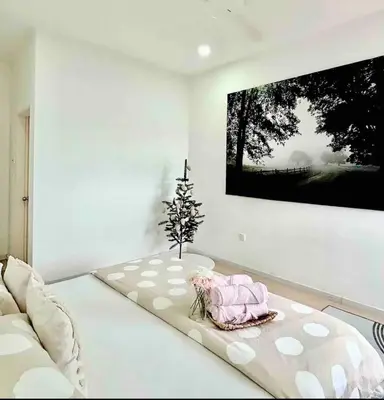 a living room with a couch and a tv on a wall at daisy apartment homestay taiping in Taiping
