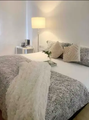 a bedroom with a bed with a white blanket on it at daisy apartment homestay taiping in Taiping