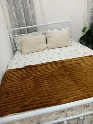 a bed with two pillows and a brown blanket at Ereens homestay 3 bedroom apartment in Brinchang
