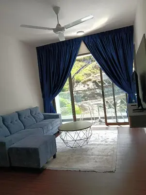 a living room with a blue couch and a table at Ereens homestay 3 bedroom apartment in Brinchang