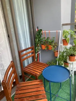 a porch with a bench and a table and potted plants at Ereens homestay 3 bedroom apartment in Brinchang