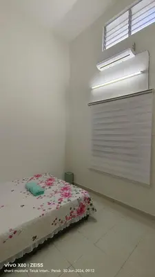a bedroom with a bed and a window with blinds at Zulfa Homestay Teluk Intan in Teluk Intan