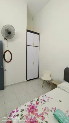 a bedroom with a bed and a closet with flowers on it at Zulfa Homestay Teluk Intan in Teluk Intan