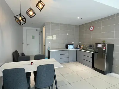 a kitchen with a table and some chairs in a room at Sunway Onsen Ipoh Tambun Cozy Retreat 8pax in Tambun