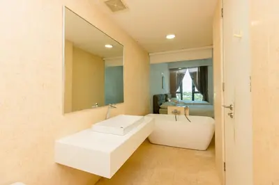 a bathroom with a white sink and a mirror at Jazz Luxury Suites BY MEXI in Tanjong Tokong