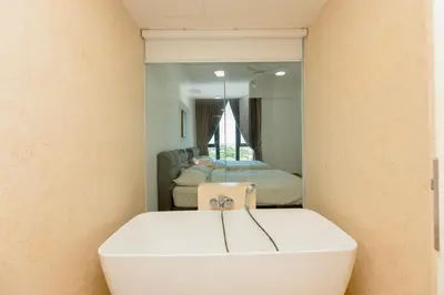 a bathroom with a white bath tub in front of a mirror at Jazz Luxury Suites BY MEXI in Tanjong Tokong
