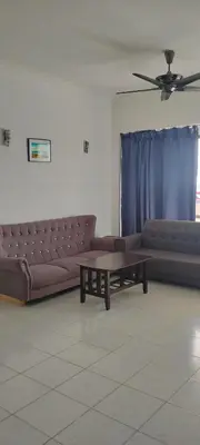 a living room with a couch and a coffee table at Bayu Emas Apartment in Batu Ferringhi