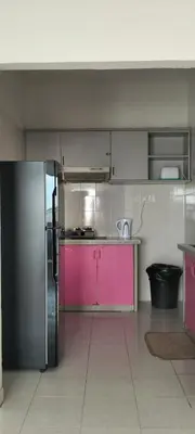 a kitchen with a pink and silver refrigerator at Bayu Emas Apartment in Batu Ferringhi