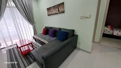 a living room with a gray couch with colorful pillows at Husinza Two LWOT in Ipoh