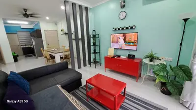 a living room with a couch and a tv at Husinza Two LWOT in Ipoh