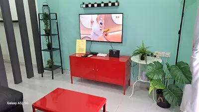 a living room with a red dresser and a flat screen tv at Husinza Two LWOT in Ipoh