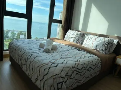 a bed in a bedroom with a large window at Sea Breeze Haven 2BR Seaview w Bathtub 海风乐园海景套房 by Minsù in Tanjong Tokong