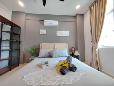 a bedroom with a large bed with a book at Ipoh Meru 3 Bedroom Suites by IWH Suites in Ipoh