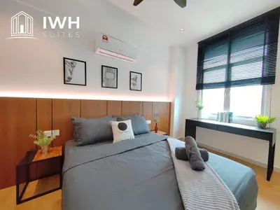 a bedroom with a large bed and a desk at Ipoh Meru 3 Bedroom Suites by IWH Suites in Ipoh