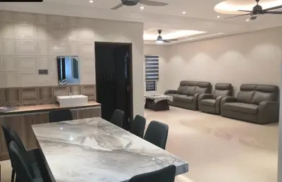 a living room with a table and chairs and a couch at Orkid Apartment Ringlet in Cameron Highlands