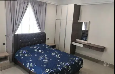 a bedroom with a bed with blue sheets and a window at Orkid Apartment Ringlet in Cameron Highlands