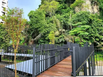 a wooden walkway with a black fence and trees at The Cove Hillside Residence Ipoh-Nature On Earth in Ipoh