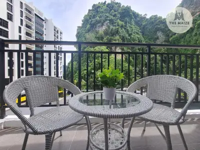 two chairs and a glass table on a balcony at The Cove Hillside Residence Ipoh-Nature On Earth in Ipoh