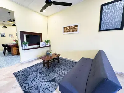 a living room with a blue couch and a table at Bercham 81 Homestay in Ipoh