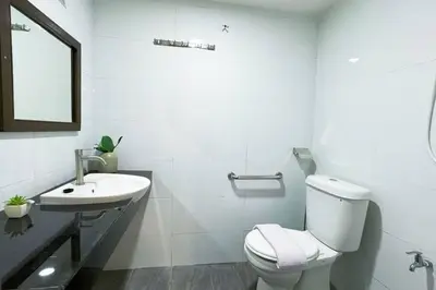 a white bathroom with a toilet and a sink at Bercham 81 Homestay in Ipoh