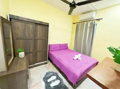 a small bedroom with a pink bed with a teddy bear on it at Bercham 81 Homestay in Ipoh